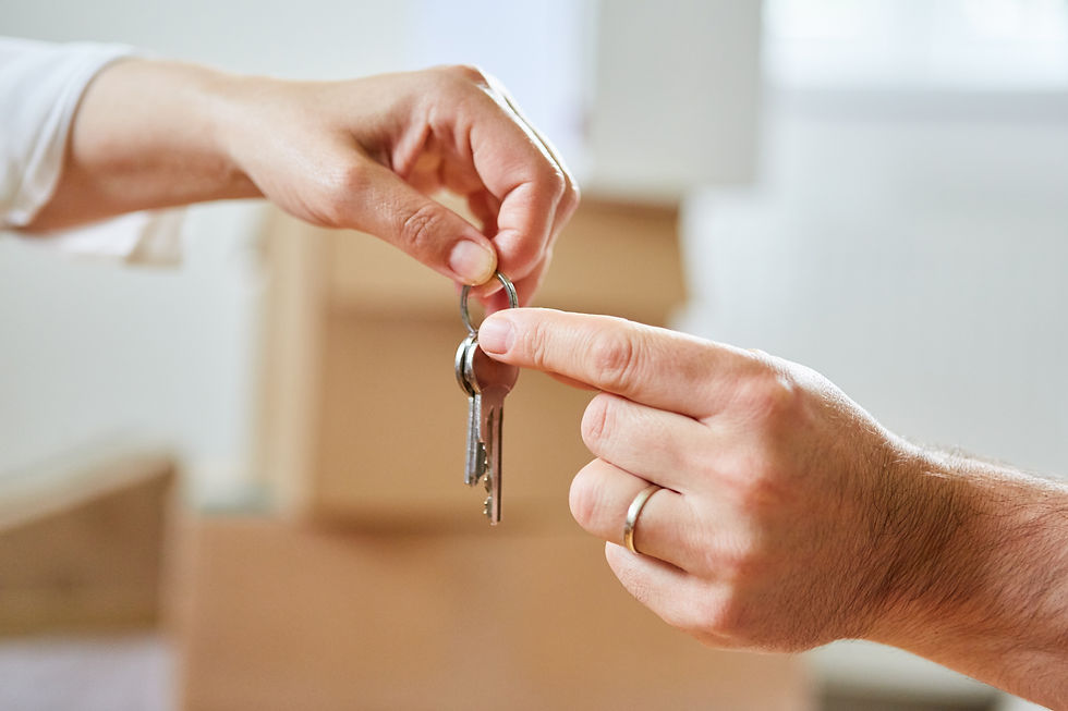 Two hands pass a house key as a symbol of real estate and house buying.jpg